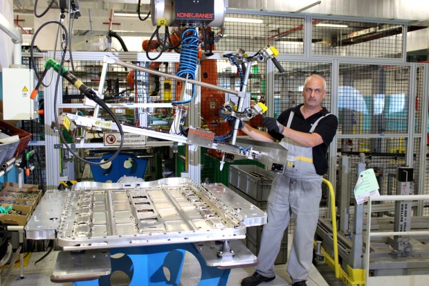 Un opérateur de montage avec un carter batterie de Renault ZOE Un opérateur de montage avec un carter batterie de Renault ZOE